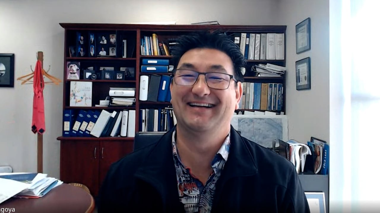 A man smiles warmly in an office.