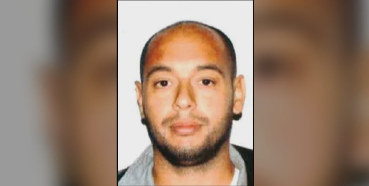 A mugshot of a balding man with a light beard
