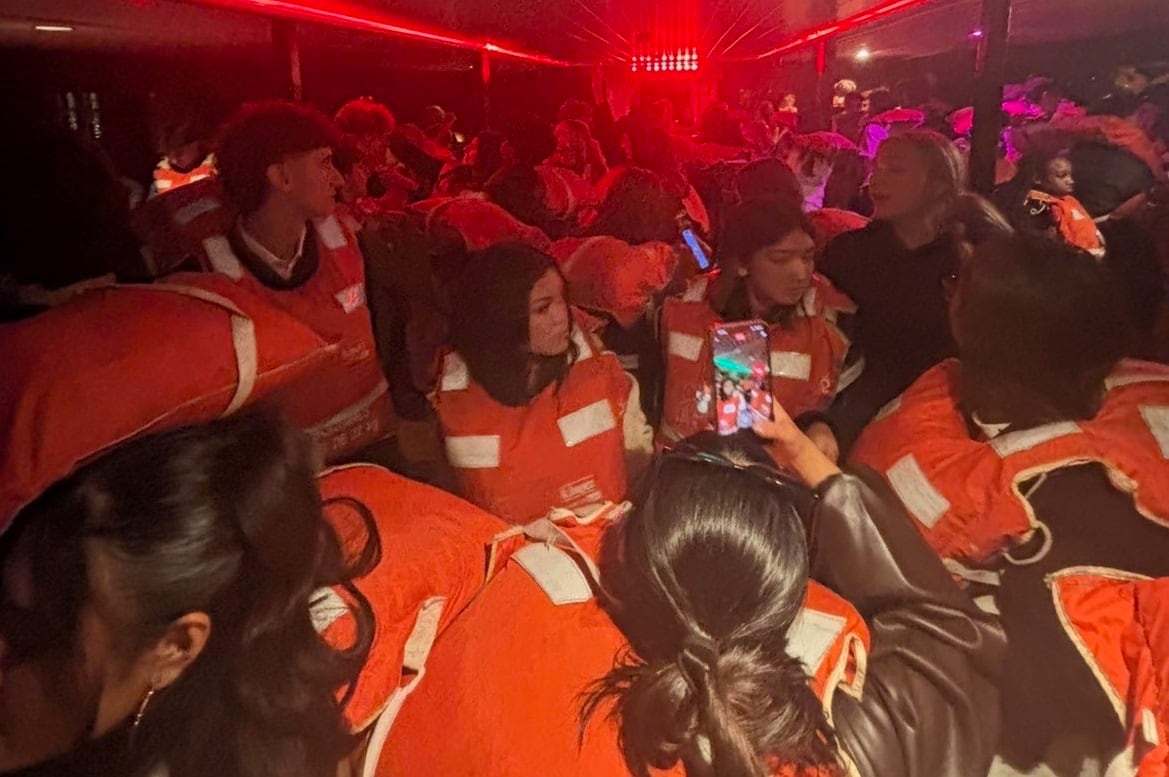 Passengers in lifejackets are pictured aboard the Pride of Vancouver vessel awaiting evacuation.