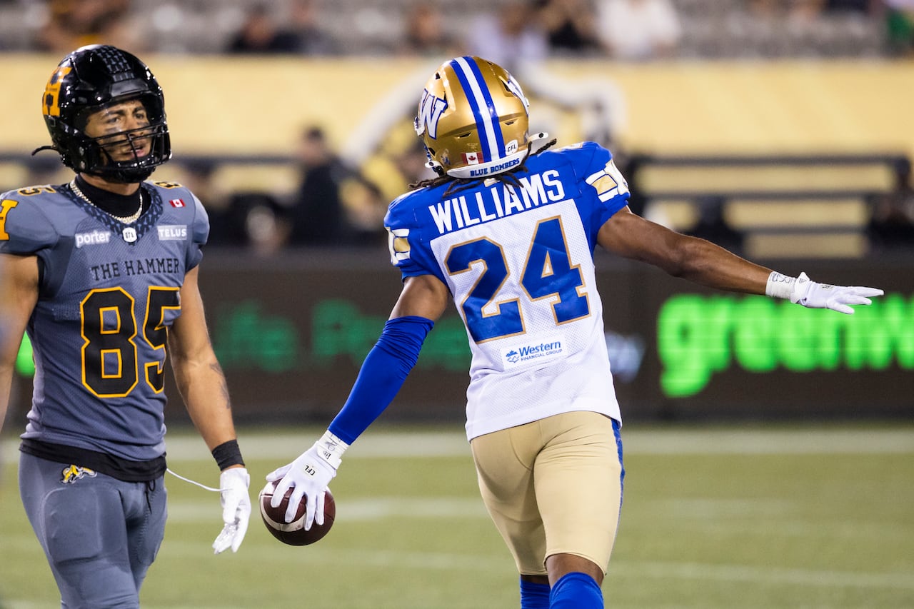 A football player in blue and white celebrates an interception.