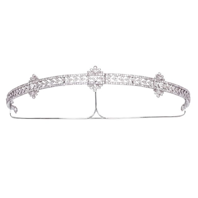 Delicate silver tiara with intricate floral design and sparkling gemstones.