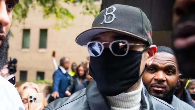 Chris Brown leaving Southwark Crown Court in cap, glasses and hat
