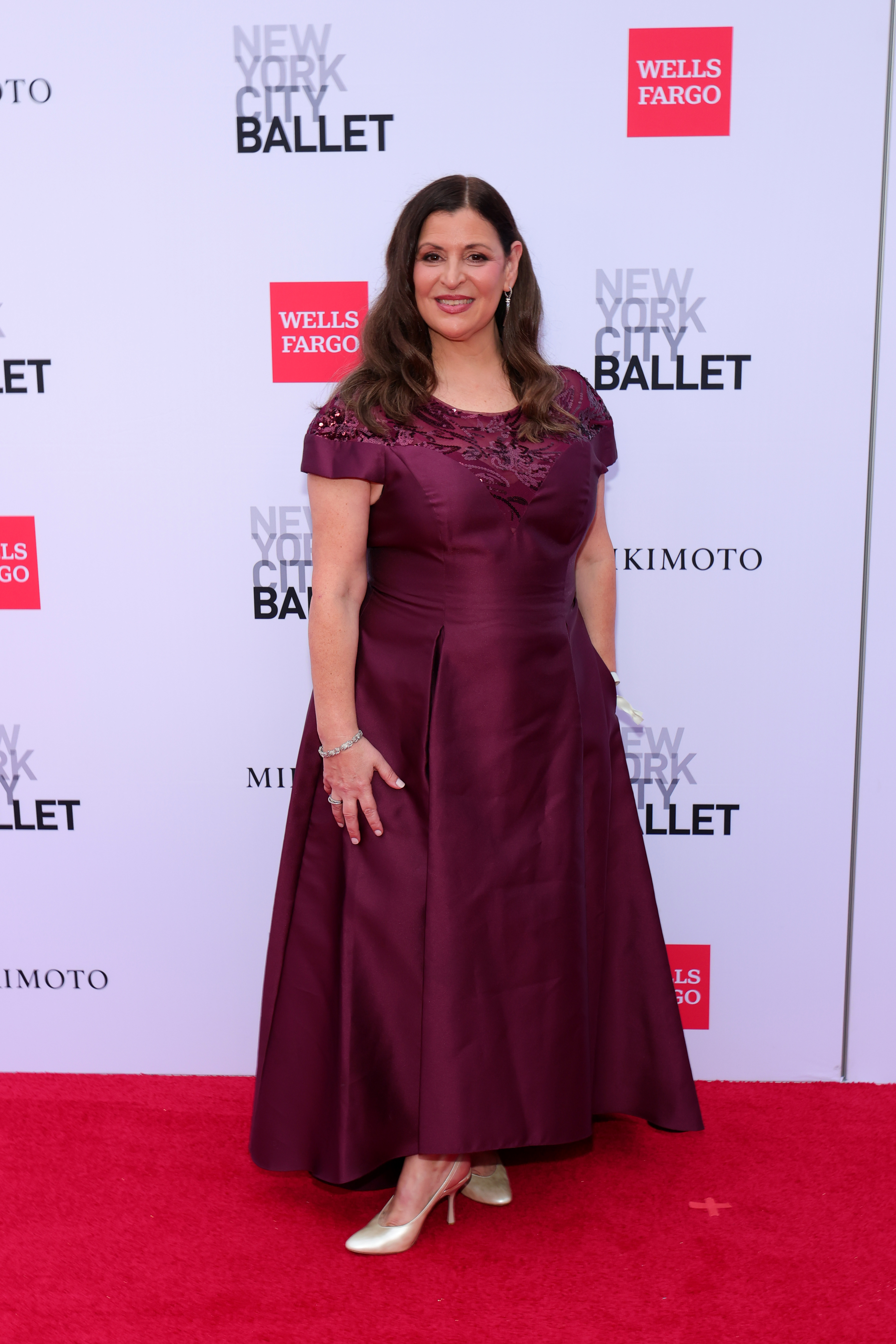 Rosina Barba poses on the red carpet wearing a plum-colored gown with sequin detailing at the New York City Ballet Fall Fashion Gala.