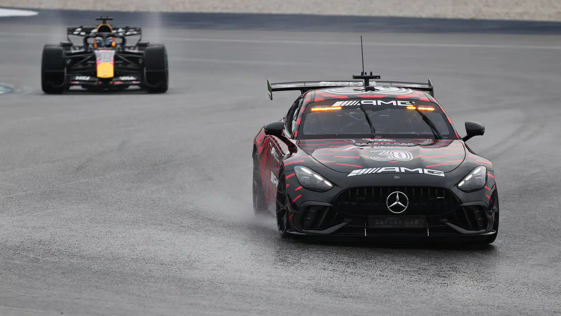 Safety car leads Max Verstappen (Red Bull-Ford) during the wet 2026 Bahrain Grand Prix
