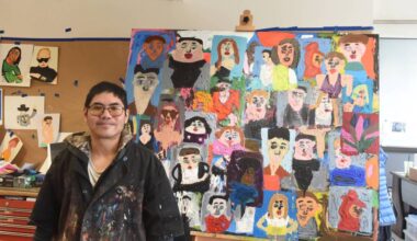 Artist Ernest Chua poses next to his 48-by-60-inch acrylic painting on canvas inside the Teegatha’Oh Zheh art studio in Whitehorse on Oct. 7. (Jake Howarth/Yukon News)