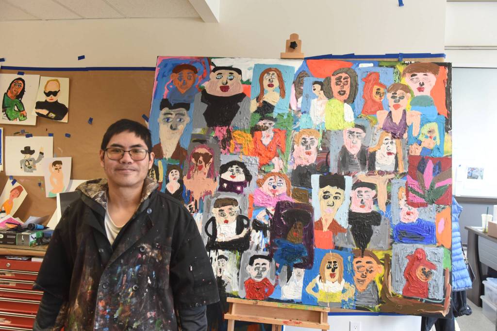 Artist Ernest Chua poses next to his 48-by-60-inch acrylic painting on canvas inside the Teegatha’Oh Zheh art studio in Whitehorse on Oct. 7. (Jake Howarth/Yukon News)
