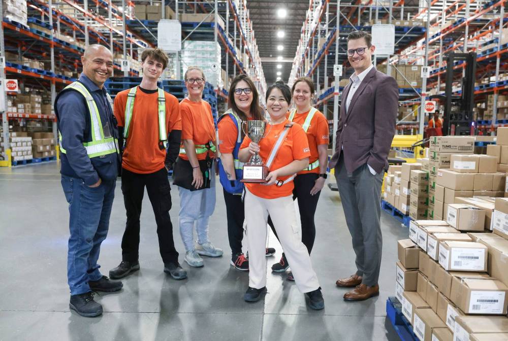 RUTH BONNEVILLE / FREE PRESS
McKesson Canada employees Robert West (from left), Liam Pickering, LaraBee Henderson, Kristina Redmond, Cathleen Isagunde, Nicole Busch and senior vice-president marketing Tim Smith show off their trophy at the Winnipeg hub.