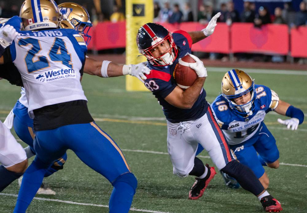 PETER McCABE / THE CANADIAN PRESS
Montreal Alouettes' Mehki Mews evades Winnipeg Blue Bombers' Jake Kelly, right, during first half CFL football action in Montreal on Saturday.