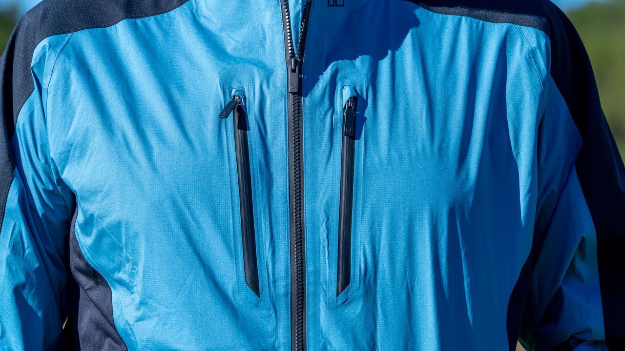 A detailed view of the FJ Arcus jacket chest area including two outer zip pockets
