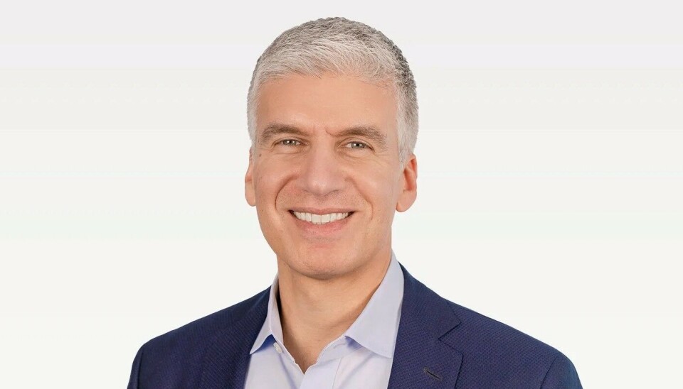 Rami Rahim smiles in a navy blazer and light blue shirt against a plain white background.