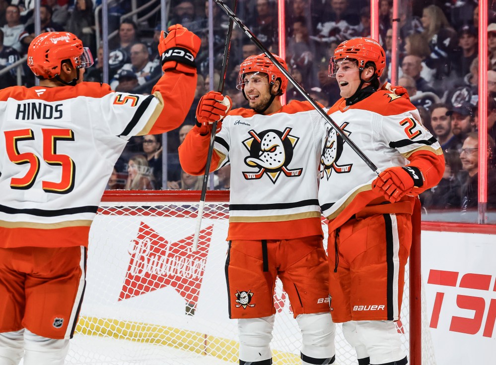 Anaheim Ducks' Tyson Hinds (55), Tim Washe (42) and Judd Caulfield (28) celebrate Caulfield's first NHL goal against the Winnipeg Jets during first period NHL action in Winnipeg on Friday, Oct. 9, 2026. THE CANADIAN PRESS/John Woods