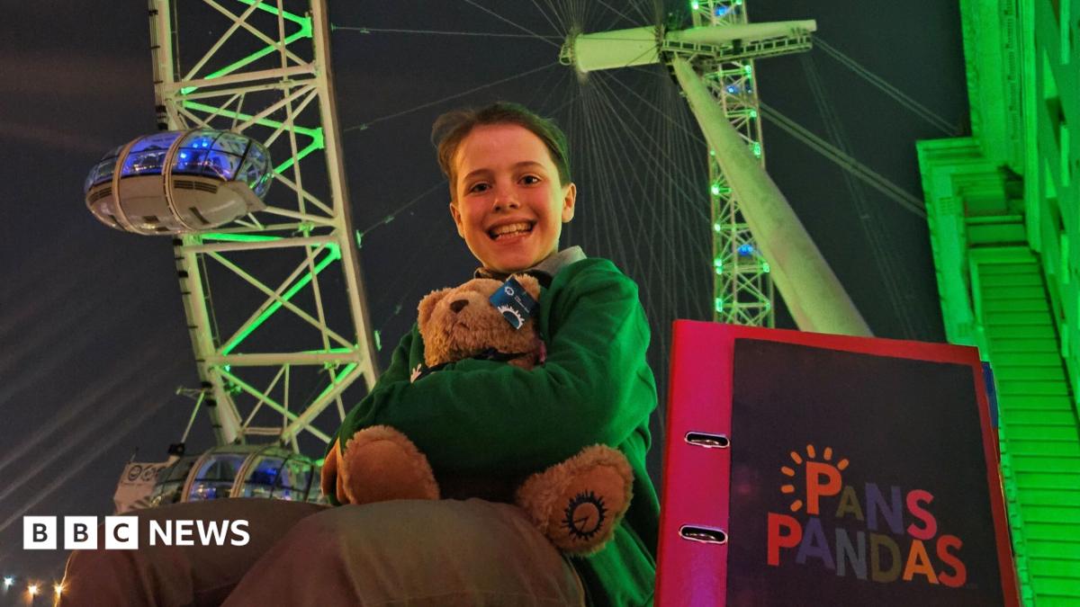 Albie is sat next to a folder saying PANS/PANDAS. Behind hims the green London eye.