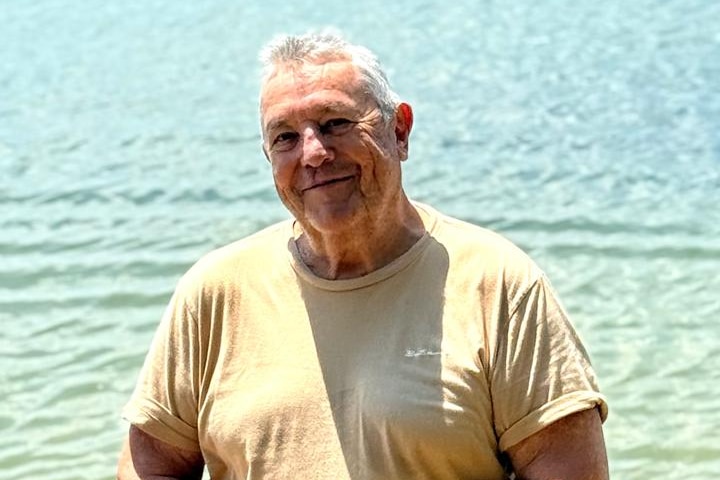 Robert Donnelly stands in shallow water at the beach.