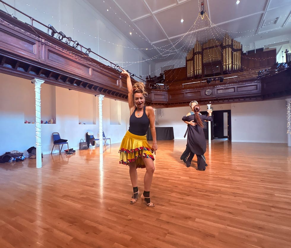 dancers in a large hall with wooden floors and an organ in the background. dancers in a large hall with wooden floors and an organ in the background.
