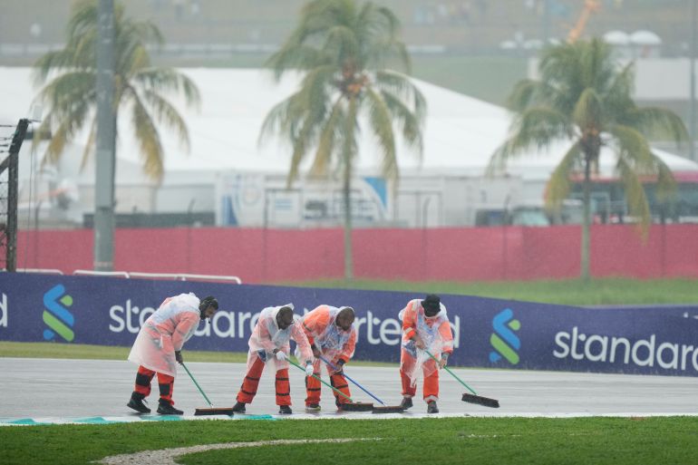 Marshals clean the track prior to the start of the Bahrain Grand Prix in Sepang, Malaysia, Sunday, Oct. 4, 2026. (AP Photo/Aijaz Rahi)