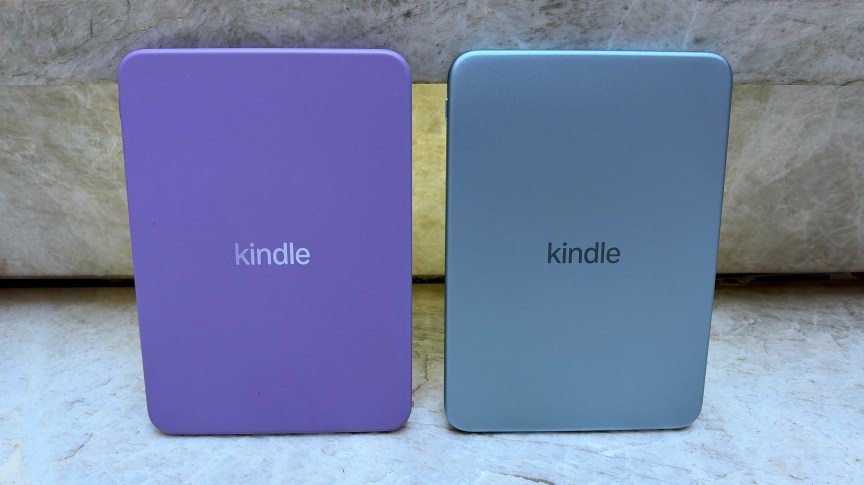 Side by side of the backs of the base Kindle 2026 with the model on the left featuring the plastic housing while the step-up version on the right features an aluminum housing.