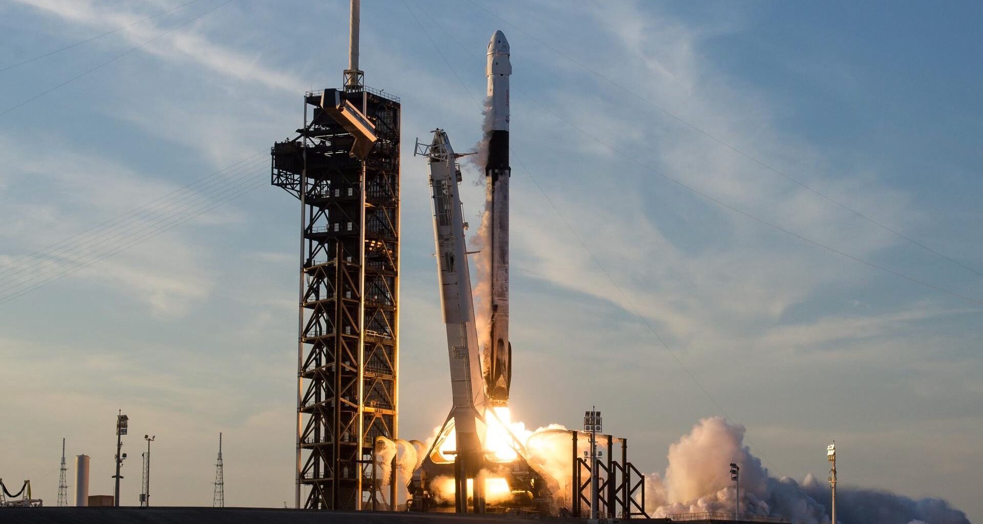 a big white rocket launches into a cloudy sky