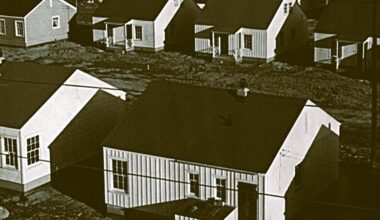 A black and white archival photo of several similar-looking homes built close together.