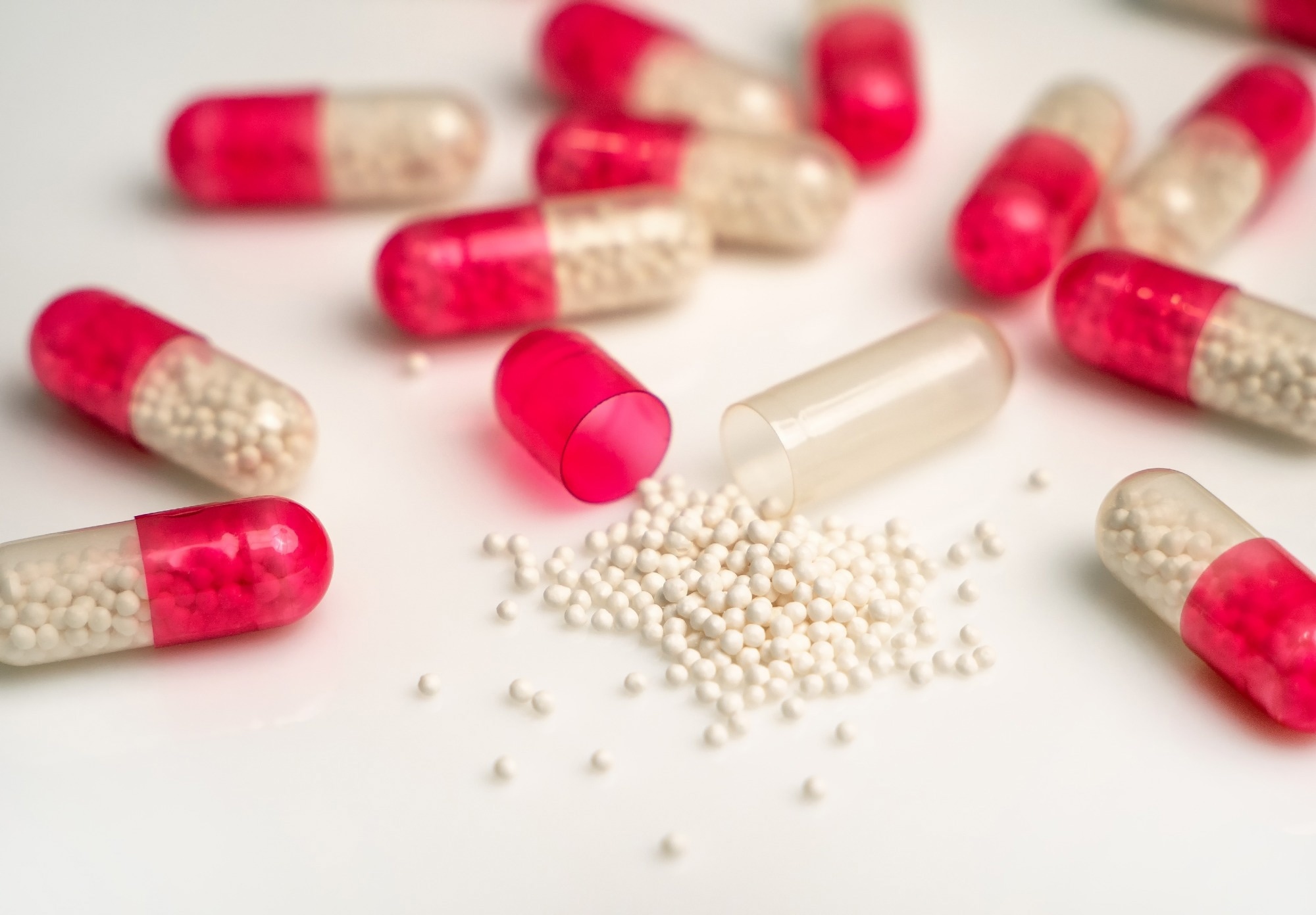Red and clear capsules containing white pellets.