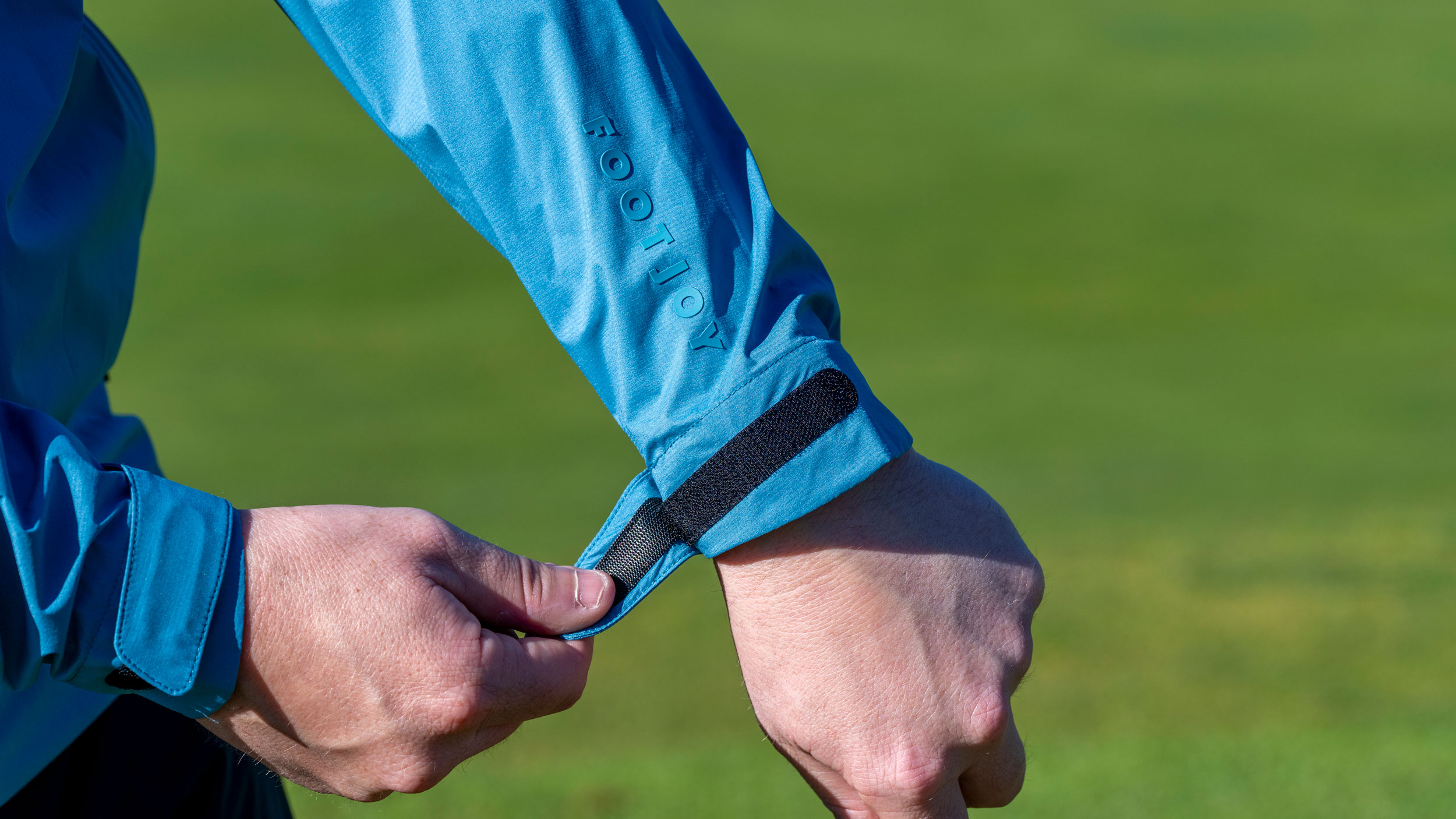 A male wearing a FJ jacket showcasing the adjustable wrist cuffs