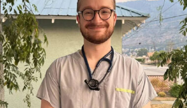 A doctor wears a stethoscope and stands in Grand Forks in the summertime.