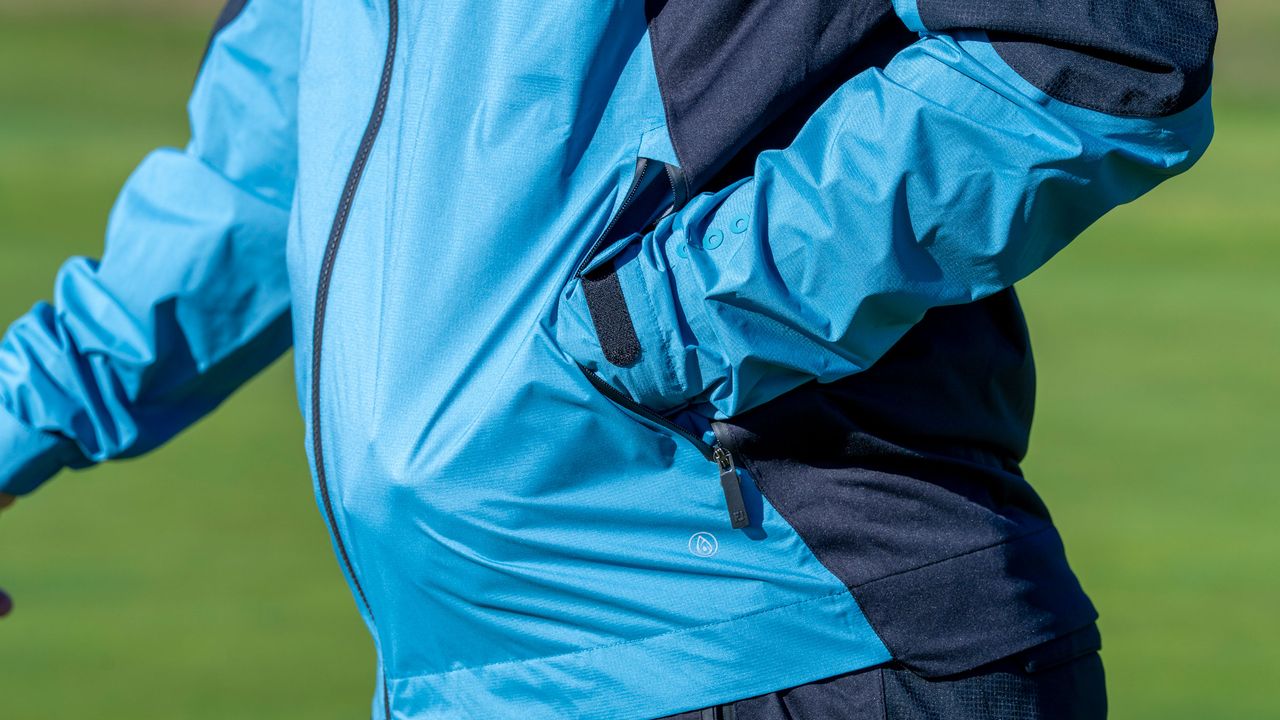 A view of a golfer with their hand in the pocket of the FJ Arcus jacket