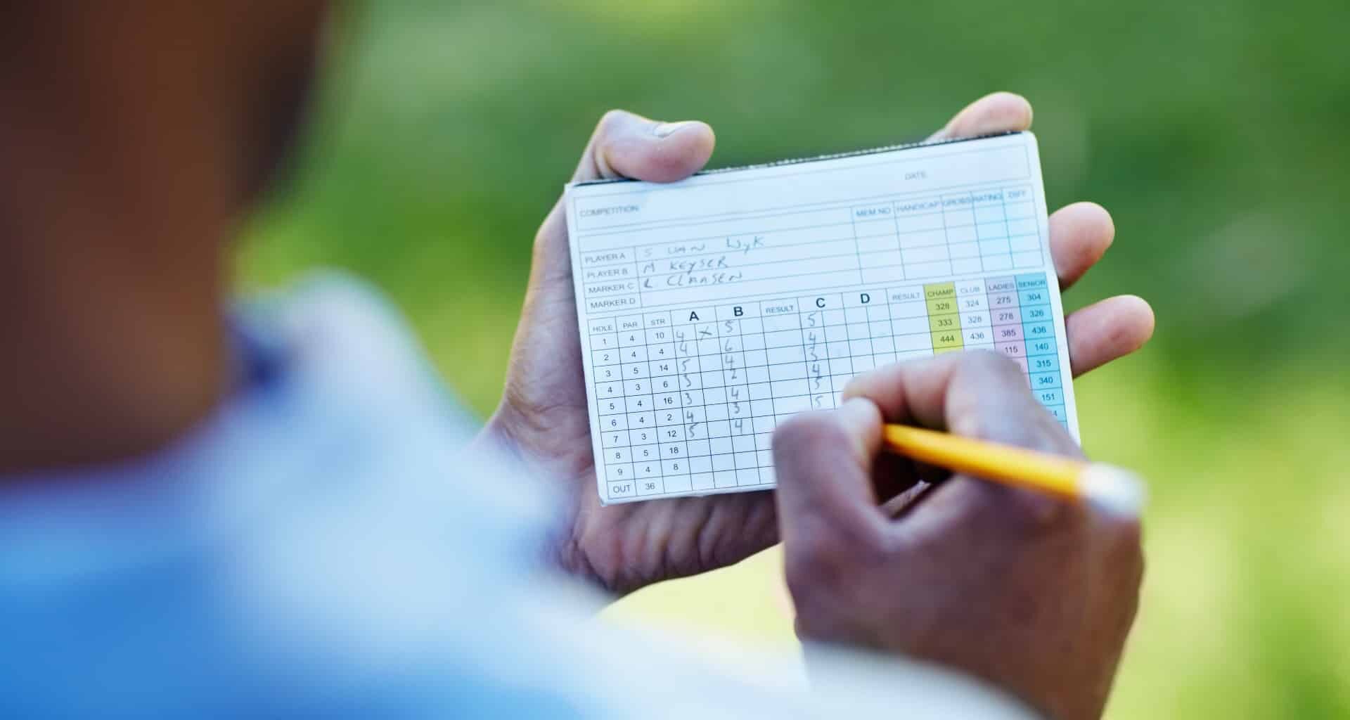 A player fills in a scorecard after a round