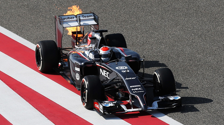 Overhead view of 2014 Sauber F1 car shooting flames on race track.