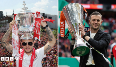 Jack Wilshere holding the FA Cup and the Vertu trophy