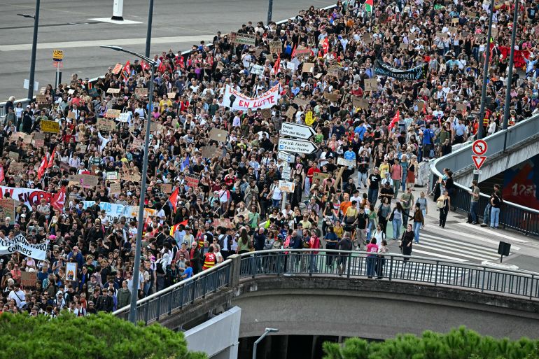 Protesters hold placards and banners during a demonstration of high-school students in Toulouse, southwestern France on October 13, 2026, as part of a nationwide high school mobilisation over learning conditions.