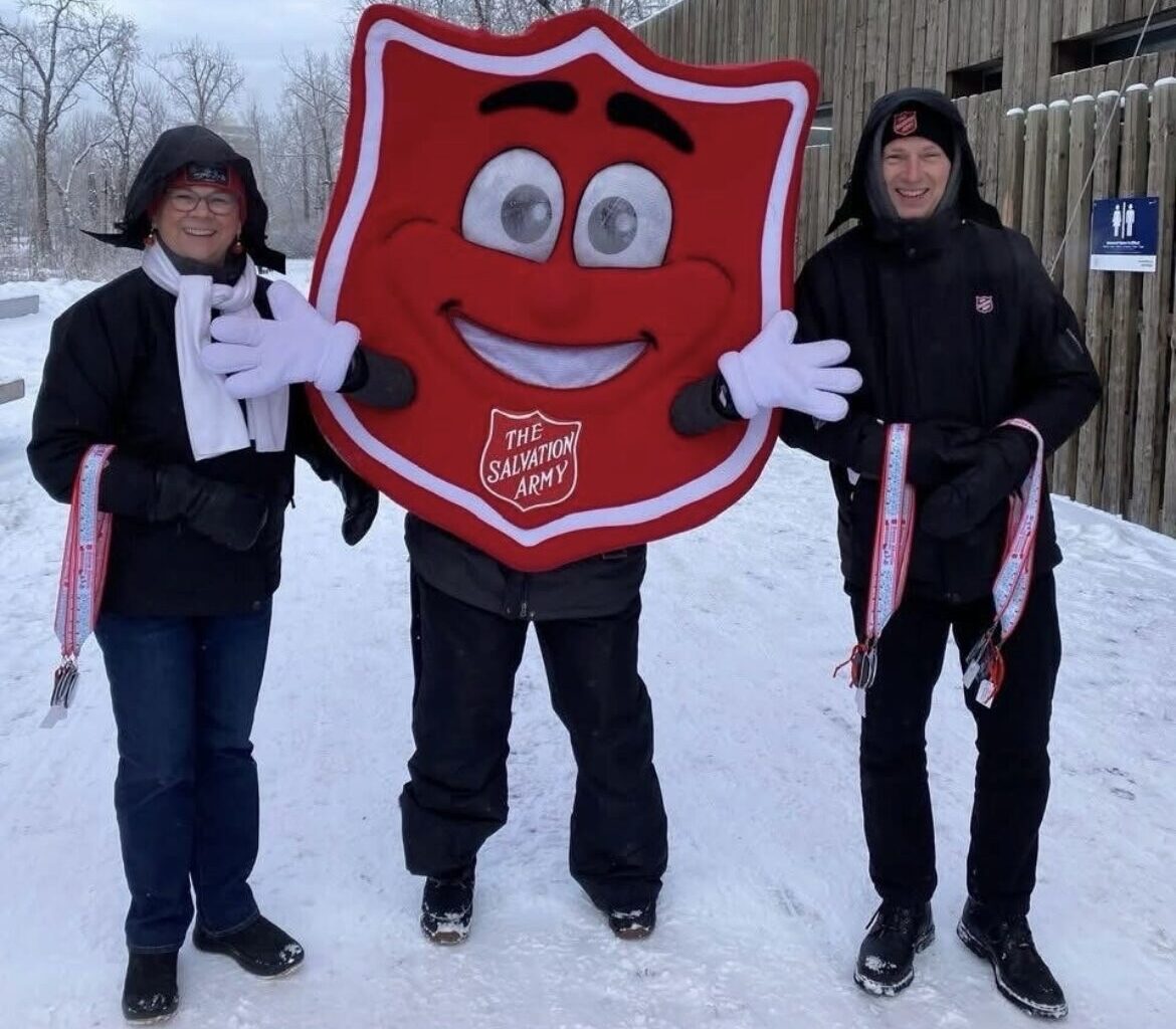 2 salvation army volunteers with the shield mascot