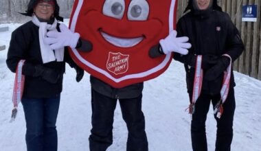 2 salvation army volunteers with the shield mascot