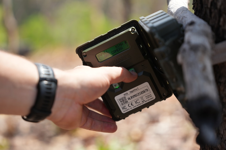 A close-up of a heavy-duty piece of technology, a hand presses a button to make the camera equipment record video footage.