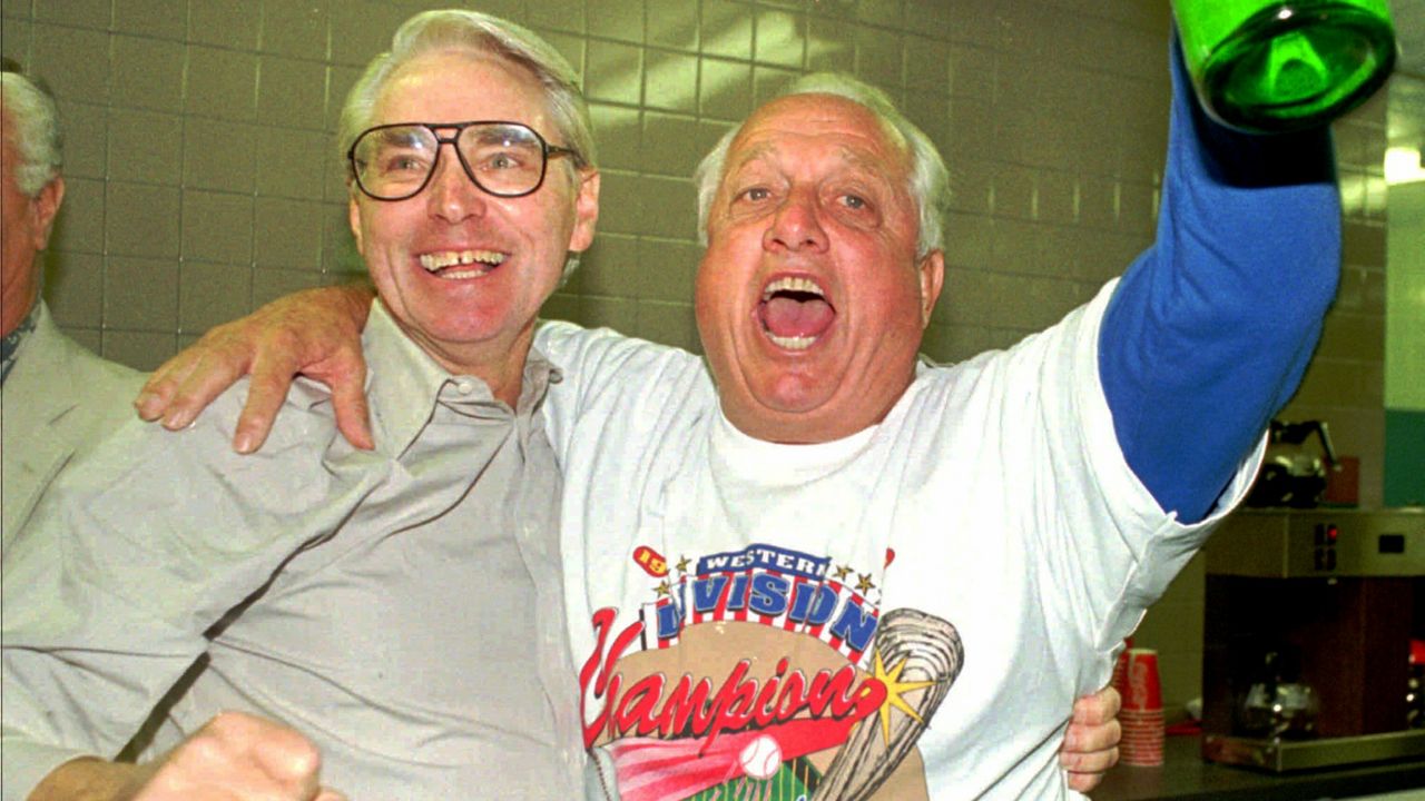 Los Angeles Dodgers executive vice-president Fred Claire, left, and manager Tommy Lasorda celebrate after the Dodgers won the National League West against the Padres, Sept. 30, 1995, in San Diego. (AP Photo/Mike Poche)