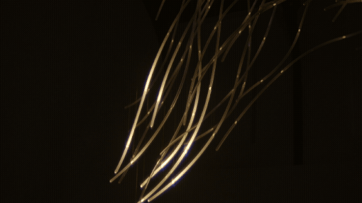 a gif of details of a suspended LED light sculpture with luminescence moving through undulating tubes