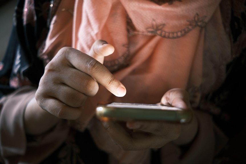 A person scrolls on their phone.