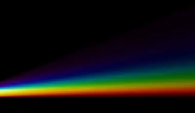 White triangular prism dispersing white light into a spectrum rainbow