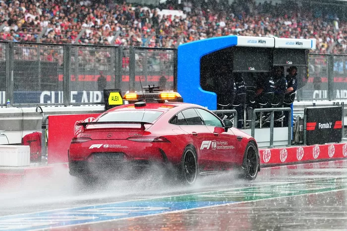 FIA Medical Car kicks up spray in the pit lane.