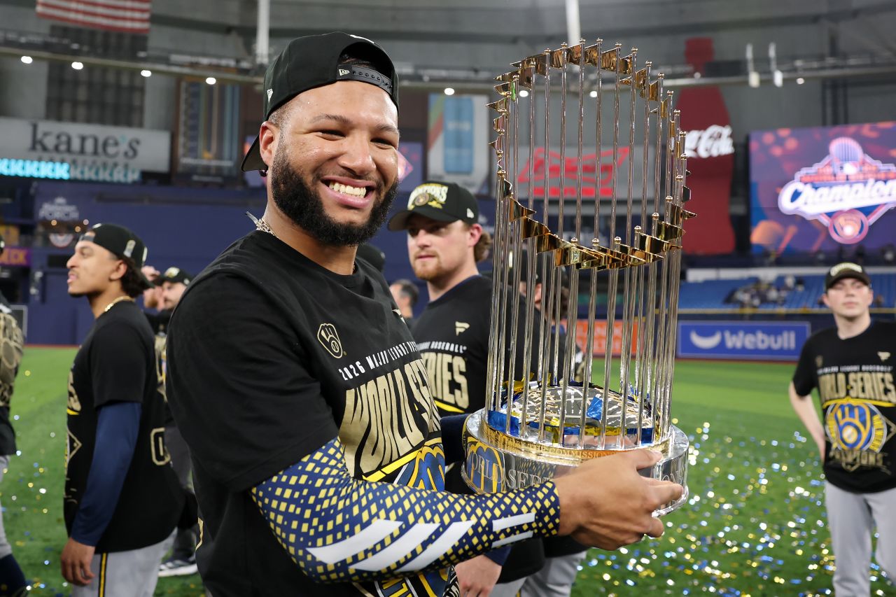 Brewers leadoff hitter Jackson Chourio poses with the Commissioner's Trophy.