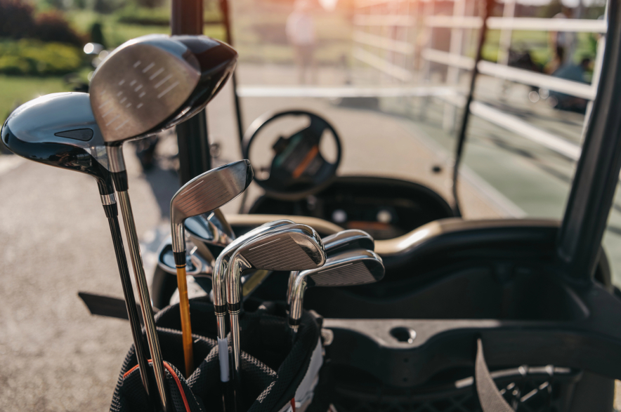 Golf clubs in the back of a cart.