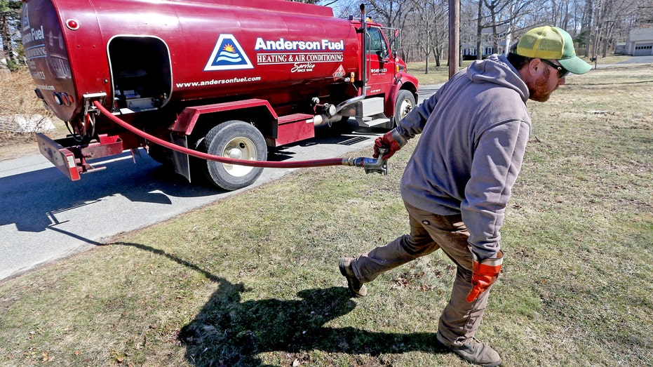 A man delivers heating oil to a home.