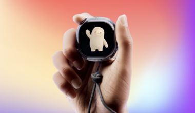 A hand holding the Muse Charm on a rainbow background
