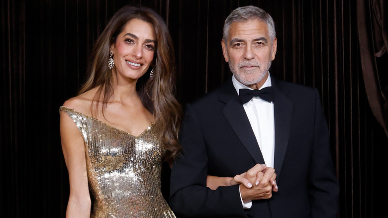 Amal Clooney in gold with George Clooney at an event