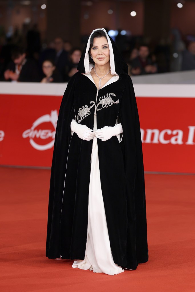 Kris Jenner wearing a black and white hooded cape with crystal scorpion embellishments on the red carpet at the Rome Film Festival.