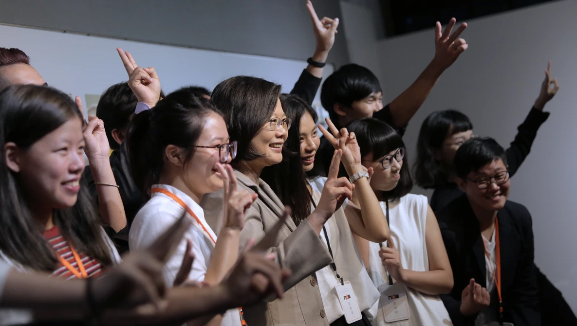 Group of women raising their hands and cheering together at an indoor event
