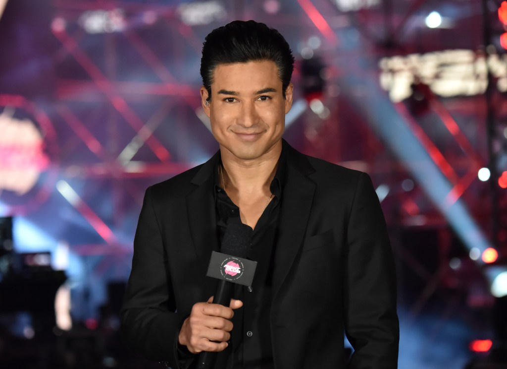 Mario Lopez holding a microphone while speaking at the Triller Fight Club boxing event.