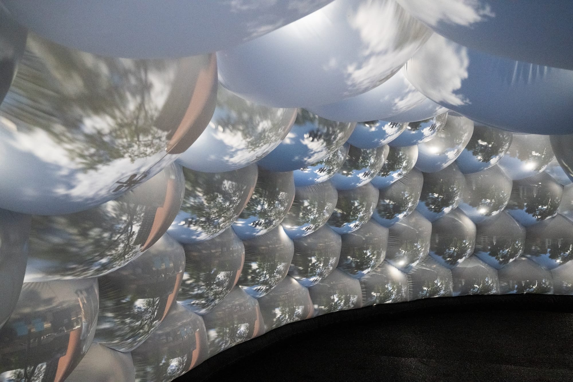 the interior of an architectural, inflatable compound camera installation with bubble-like forms featuring images of outside captured by tiny apertures