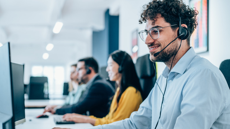 Various customer support agents sitting with headphones and mics on
