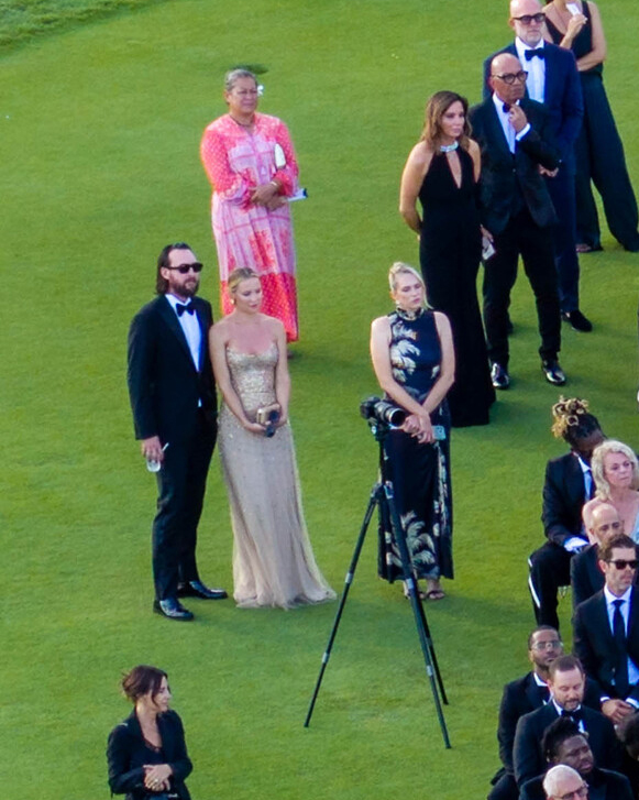 Kate Hudson and Danny Fujikawa stand among guests at a wedding outdoors on a grassy lawn.