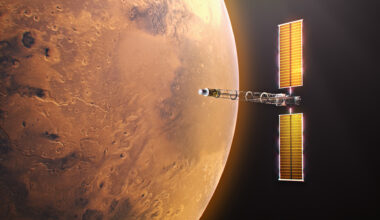 Digital illustration of the Space Reactor-1 (SR-1) Freedom spacecraft in orbit near Mars. The planet's red terrain fills the left half of the frame. On the right, the spacecraft is oriented horizontally, showcasing its central Power and Propulsion Element bus flanked by two tall, illuminated golden Roll-Out Solar Arrays. An elongated open-truss boom extends forward from the bus, ending at the cylindrical nuclear fission reactor and power conversion module.